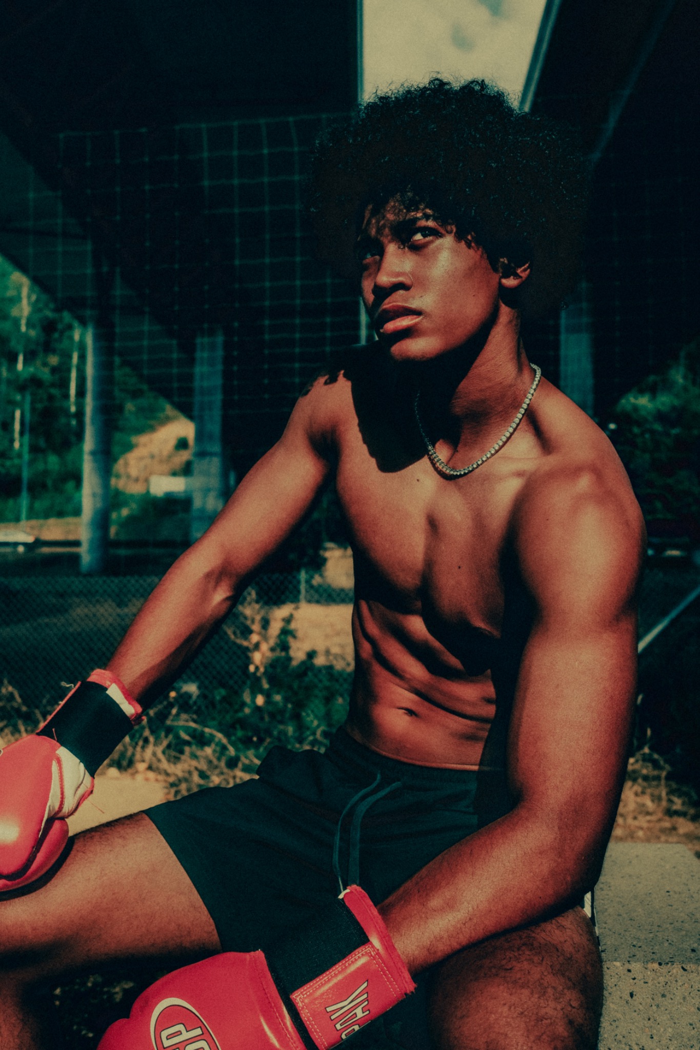 Editorial portrait of a boxer resting beneath an overpass